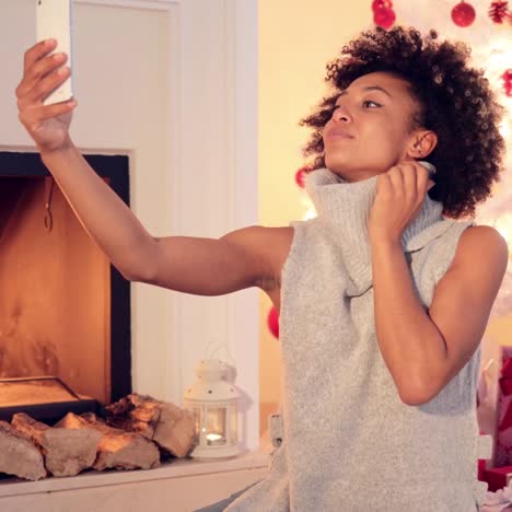 mujer joven con estilo tomando un selfie navideño