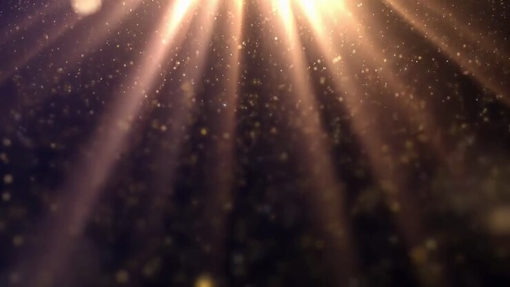 Abstracte video met gouden lichtstralen en deeltjes, vanuit een laag standpunt bekeken