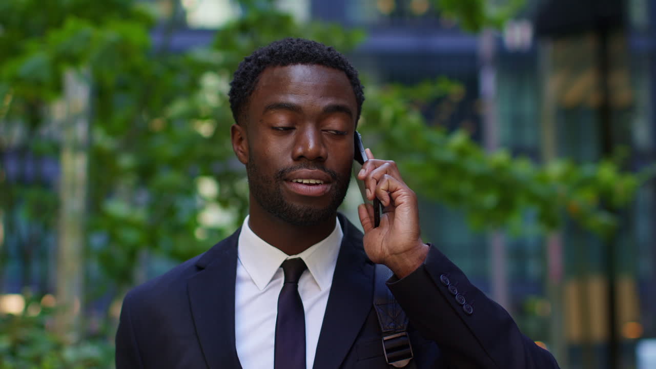 Close Up Of Young Businessman Wearing Suit Talking On Mobile Phone Standing Outside Offices In The Financial District Of The City Of London UK 2