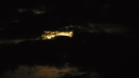 Lapso-De-Tiempo-De-Las-Nubes-Nocturnas-Que-Pasan-Con-Una-Luna-Iluminada-Que-Se-Eleva-Detrás