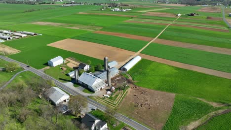 farm with silo storage and agricultural fields in vermont at sunny day in spring