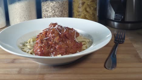 Slow-Motion-Shot-of-Parmesan-Being-Grated-on-to-Pasta-and-Tomato-Sauce