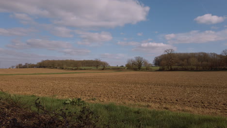 slow camera pan over barren farmers field in the spring sunshine