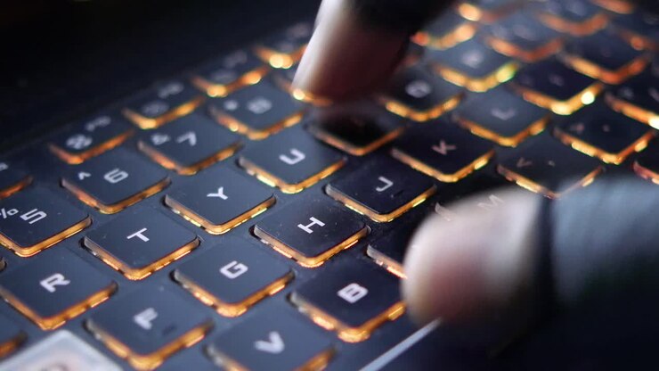 Hackerhånd stjæler data fra bærbar computer, set ovenfra