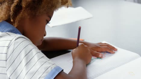 Seitenansicht-Eines-Amerikanischen-Afrikaners,-Der-Im-Klassenzimmer-Eine-Skizze-Auf-Einem-Notizbuch-Zeichnet-4k