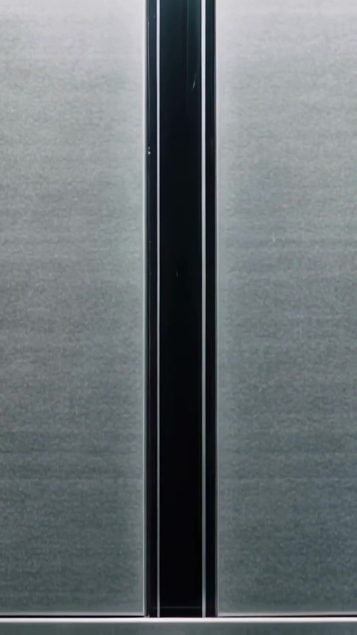 Vertical video: Closing lift door raising rail to align with central mullion, showing metal panels