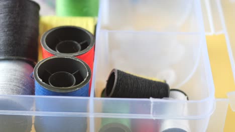 hilo de coser de colores en un organizador de plástico