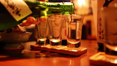 sequence of sake being poured into glasses