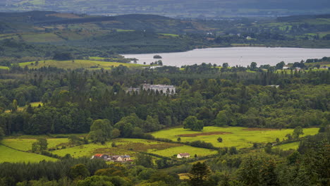 Lapso-De-Tiempo-Del-Paisaje-Agrícola-Rural-Con-Lago,-Bosque-Y-Castillo-De-Kilronan-Durante-Un-Día-Nublado-Visto-Desde-Arriba-Lough-Meelagh-En-El-Condado-De-Roscommon-En-Irlanda