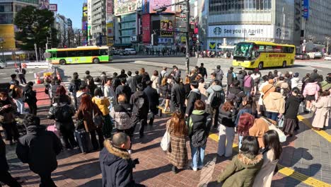 crowds crossing a busy urban intersection