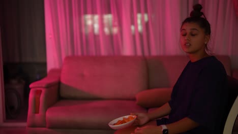 mujer viendo televisión y comiendo bocadillos