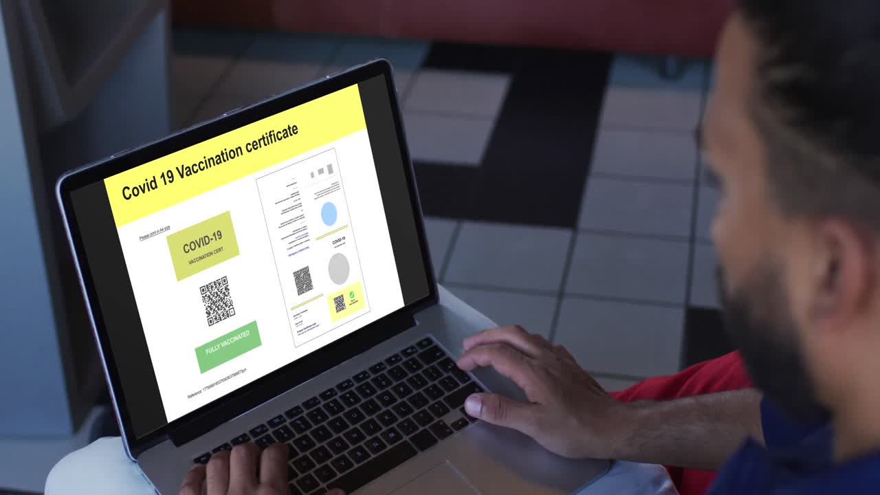 hombre trabajando en la mesa, certificado de vacunación contra la covid con código qr en la pantalla del portátil