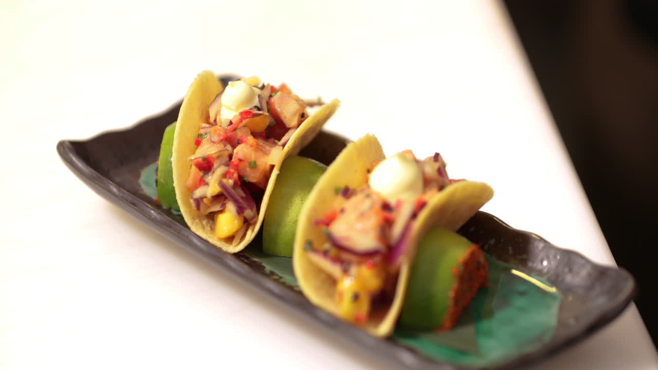 Chef che mette maionese sopra i Sushi Tacos.