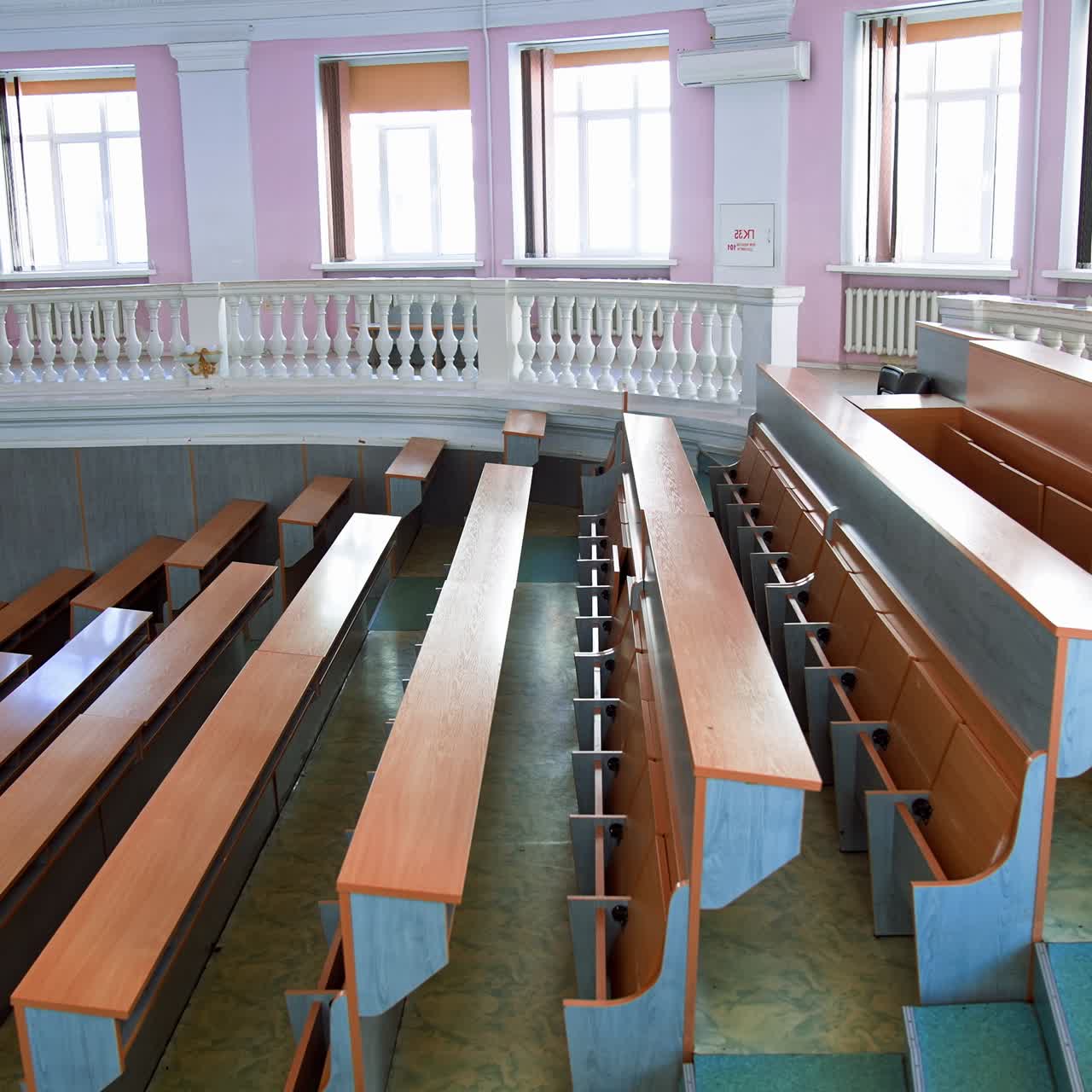 New auditorium for conference meeting. Empty lecture hall in the university during quarantine. Spacious classroom with rows of long desks for students to study