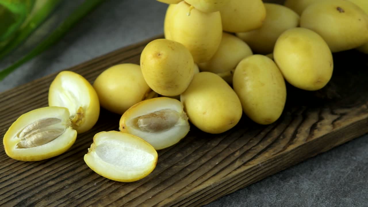 las palmeras de dátiles frescas se colocan en la mesa con aceite, concepto de alimentos saludables. palmeras de dátils. frutas crudas de palmieras de dátiles (phoenix dactylifera)