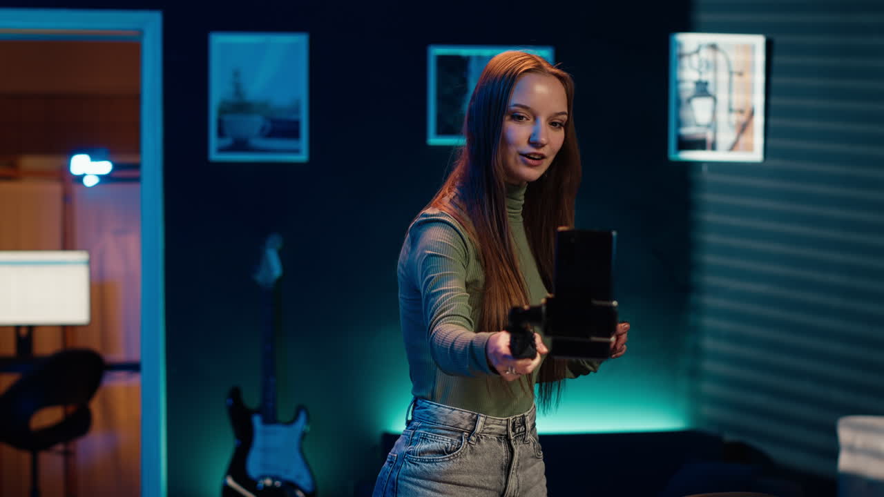 estrella de los medios en el estudio casero utiliza el teléfono móvil para filmar a sí misma