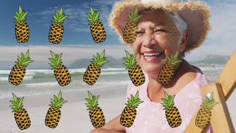 Animation-of-pineapple-over-happy-senior-biracial-woman-sunbathing-on-beach