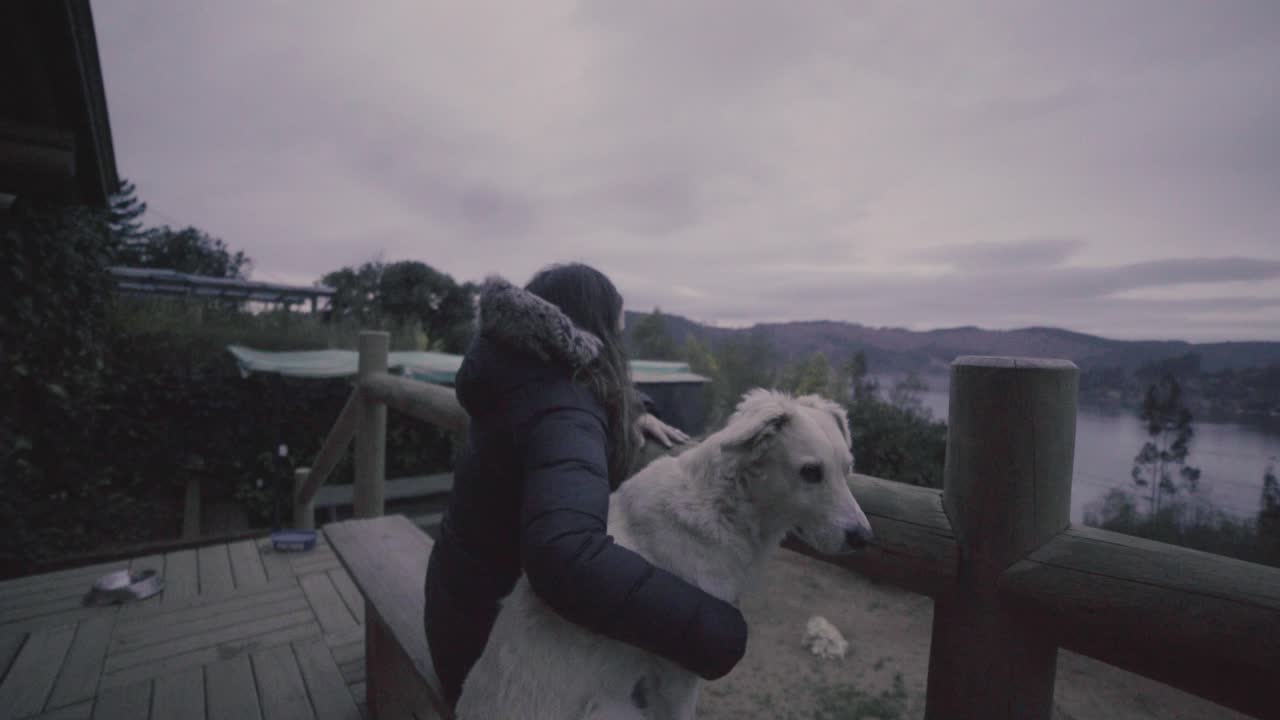 hd de una mujer y su casa de perro al aire libre frente a un lago