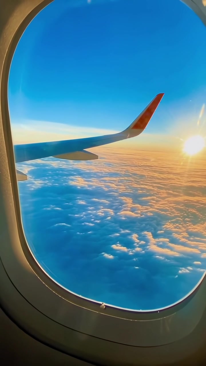 Udsigt til flyvinge over skyer under solnedgang