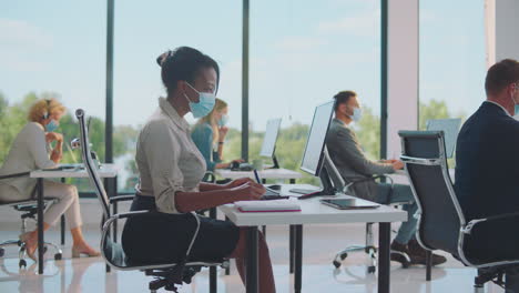 businesspeople working in modern office during pandemic