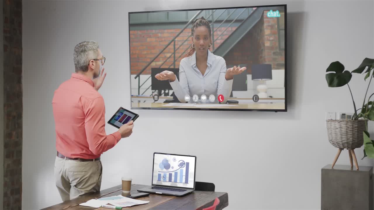 Caucasian businessman on video call with african american female colleague on tv screen