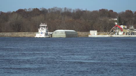 Schleppboot-Manövriert-Einen-Kleinen-Schüttgutkahn-Auf-Dem-Mississippi-River-In-Moline,-Illinois