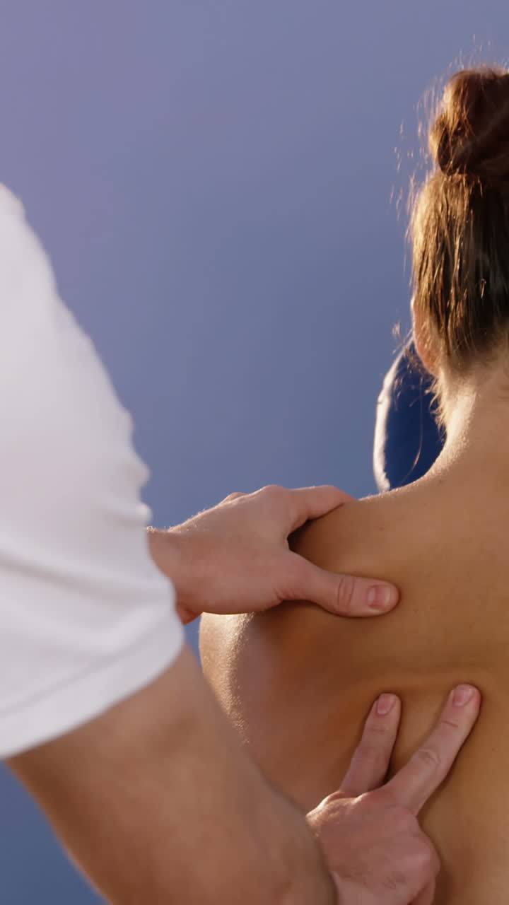 Male physiotherapist giving back massage to female patient