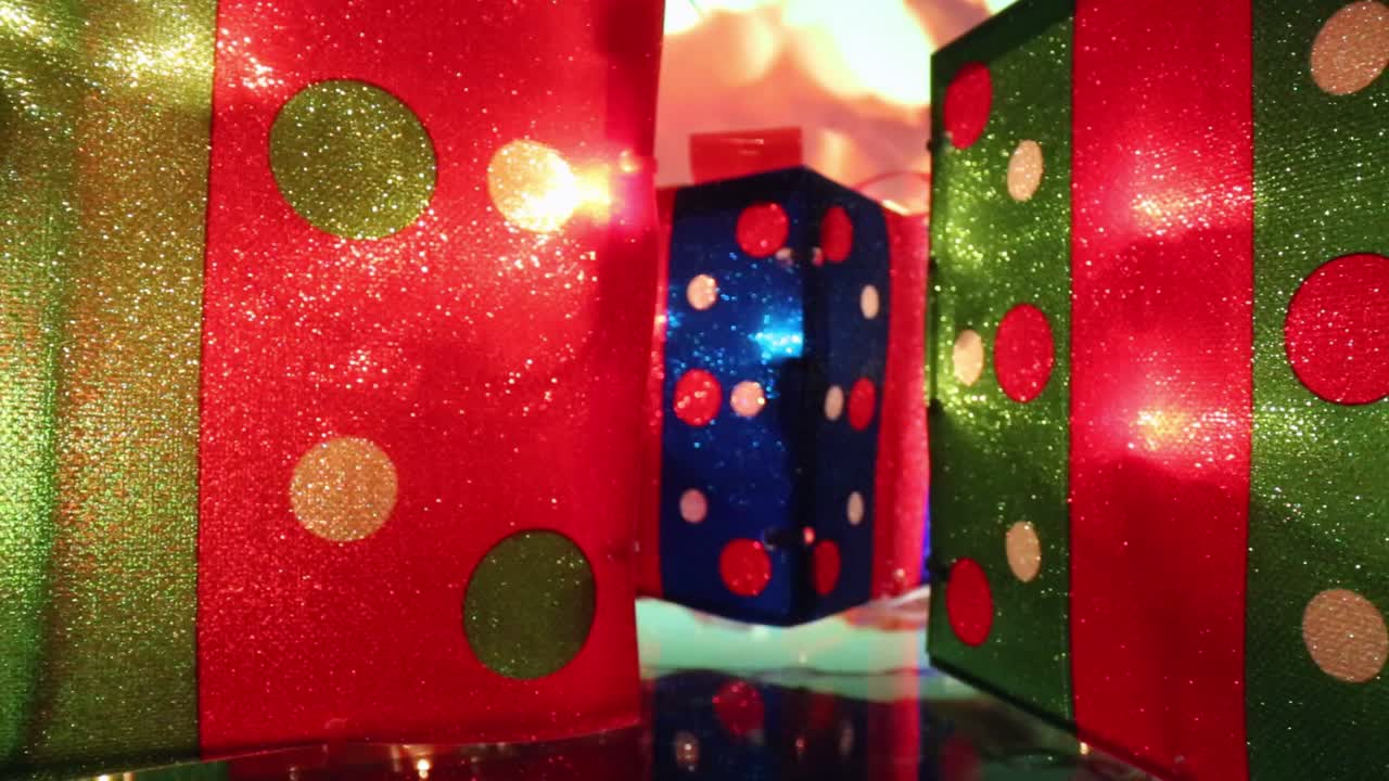 alejándose del rojo con puntos de polka - regalo de navidad iluminado en azul en el medio a medida que el fondo cambia de color