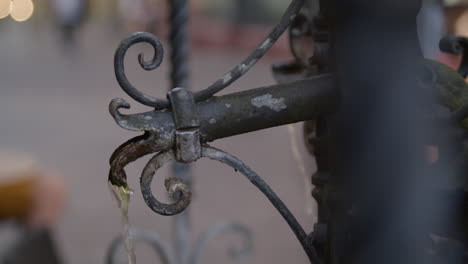 close up of water flowing from an ornate metal water fountain