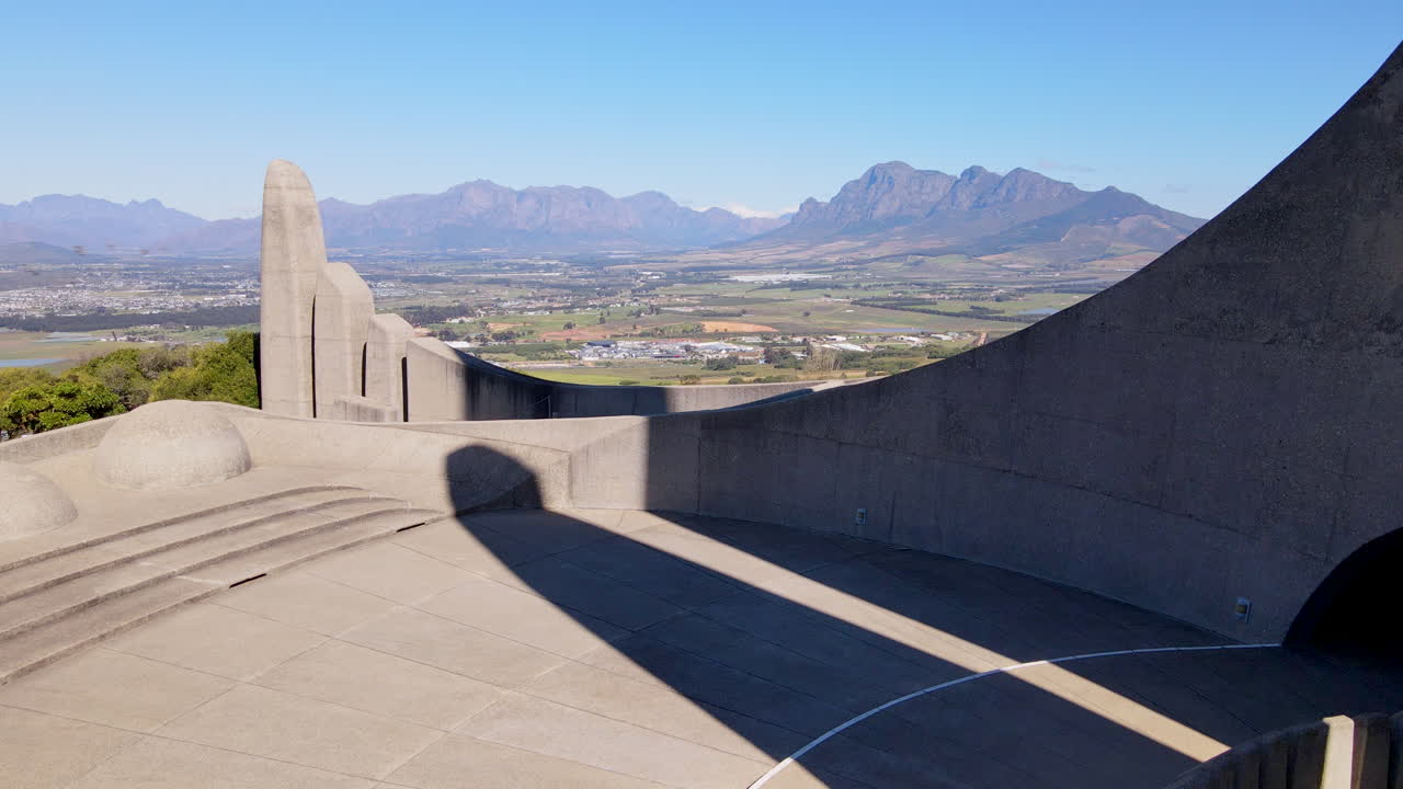 Low aerial at symbolic Afrikaans language monument overlooking Paarl and farm lands of Stellenbosch in Western Cape South Africa
