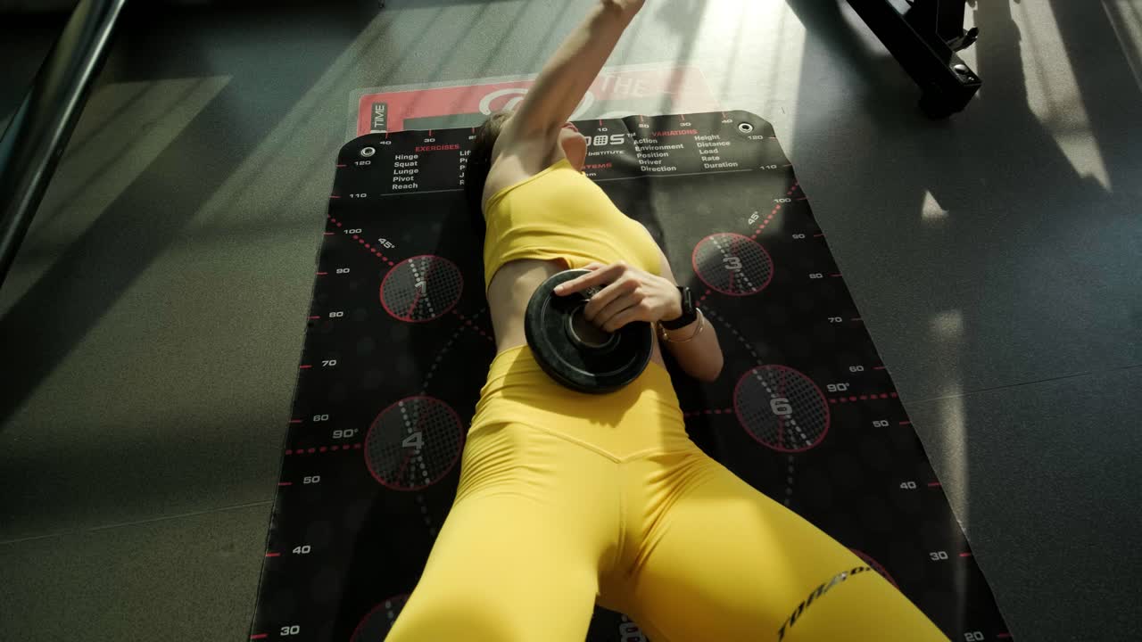 아름다운 소녀가 숫자를 가진 특별한 매트에서 훈련하고 있습니다.