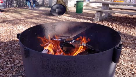 Close-up-rotating-around-daytime-campfire-outdoors-with-open-flame