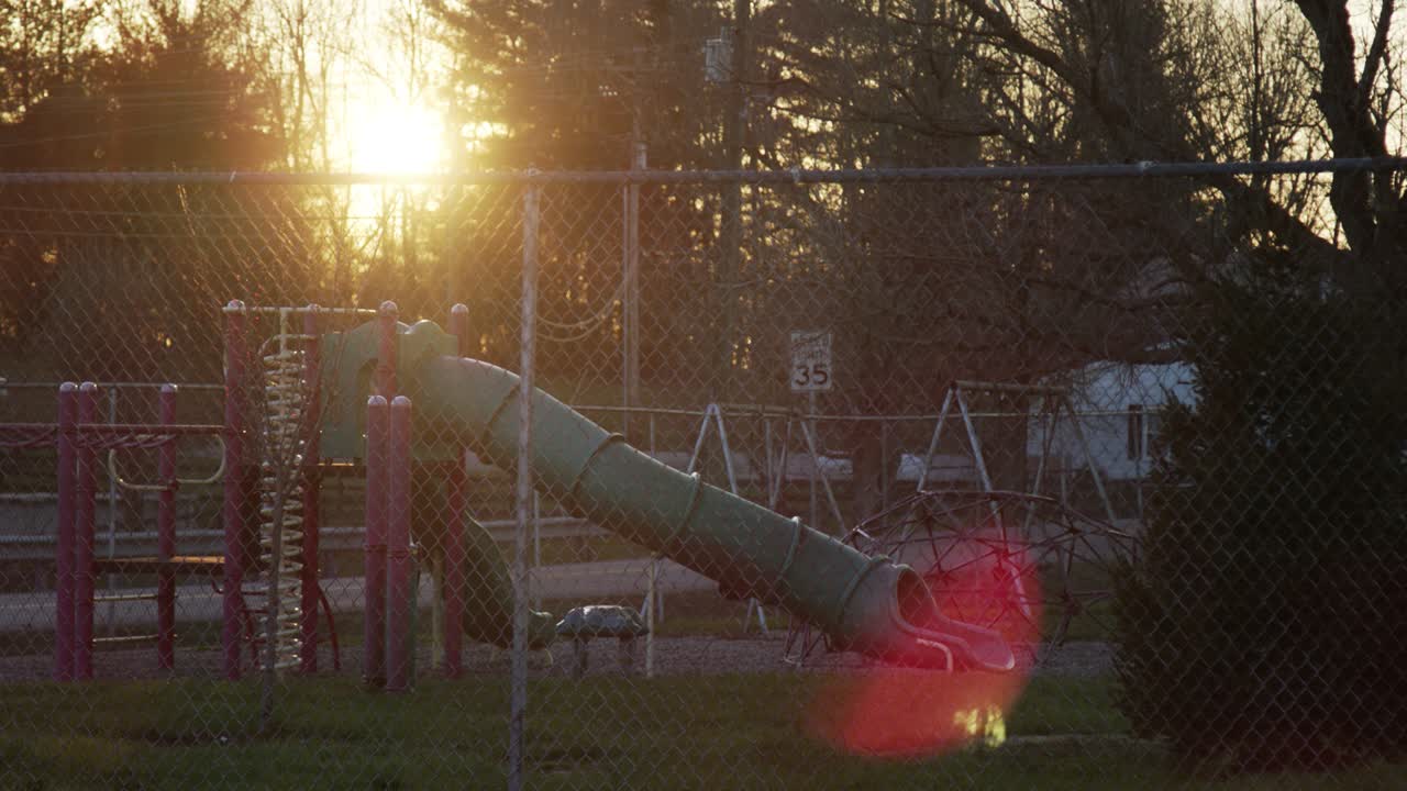 Playground Through Fence At Sunset