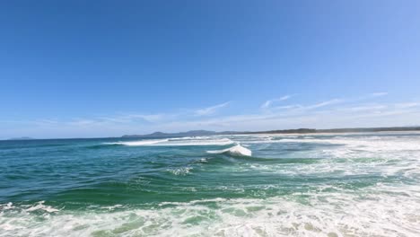 ocean waves crashing under a clear blue sky