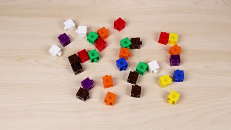 hands organize colorful cubes on a table