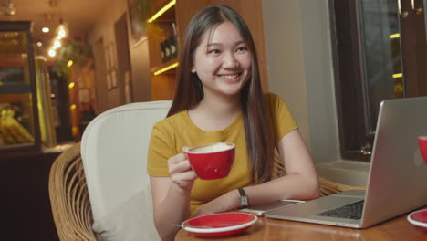 happy young asian woman drink coffee with someone