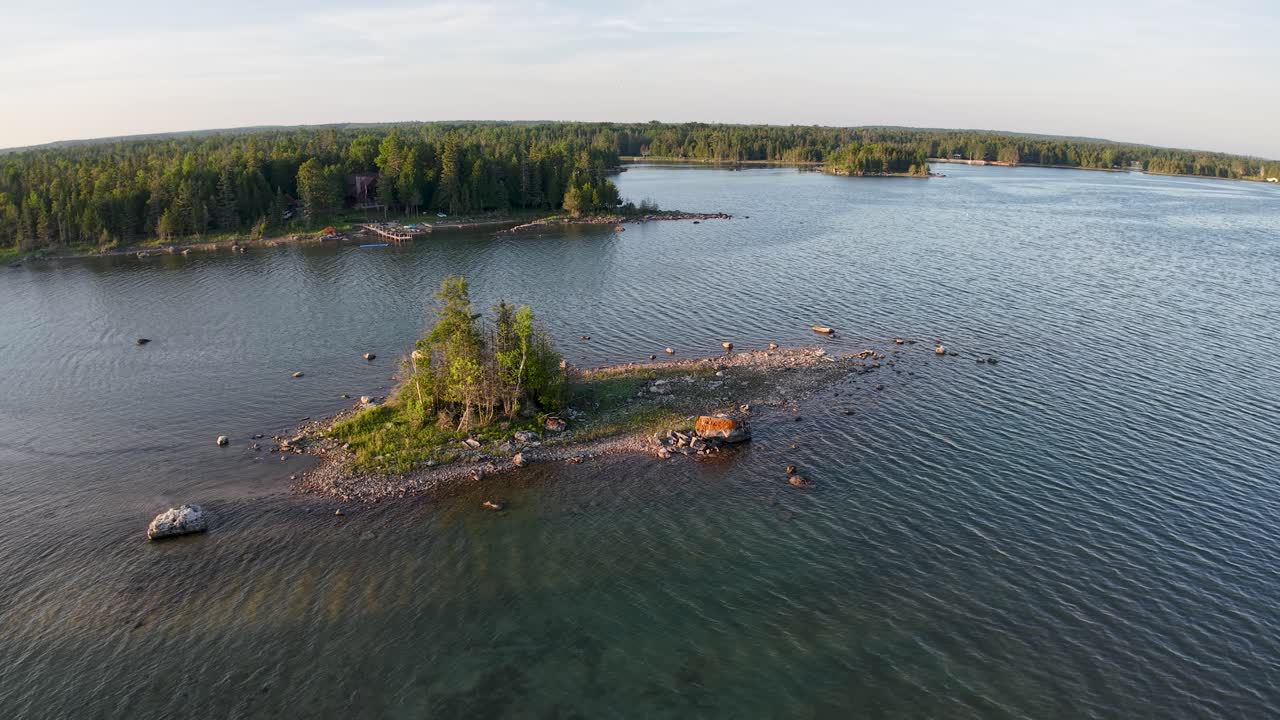 Aerial drone view of rocky islets with scattered trees surrounded by calm waters in Michigan’s Upper Peninsula, Les Cheneaux Islands