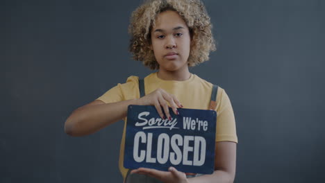 business owner holding open/closed sign