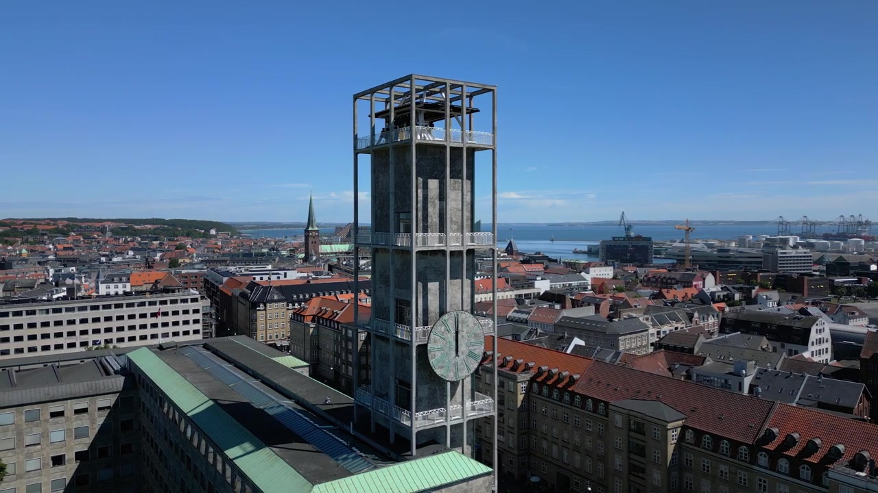 Torre dell'orologio del Municipio di Aarhus che si affaccia sul centro città e sul porto in Danimarca, ripresa aerea con orbita media attorno a un'area protetta e rinforzata.
