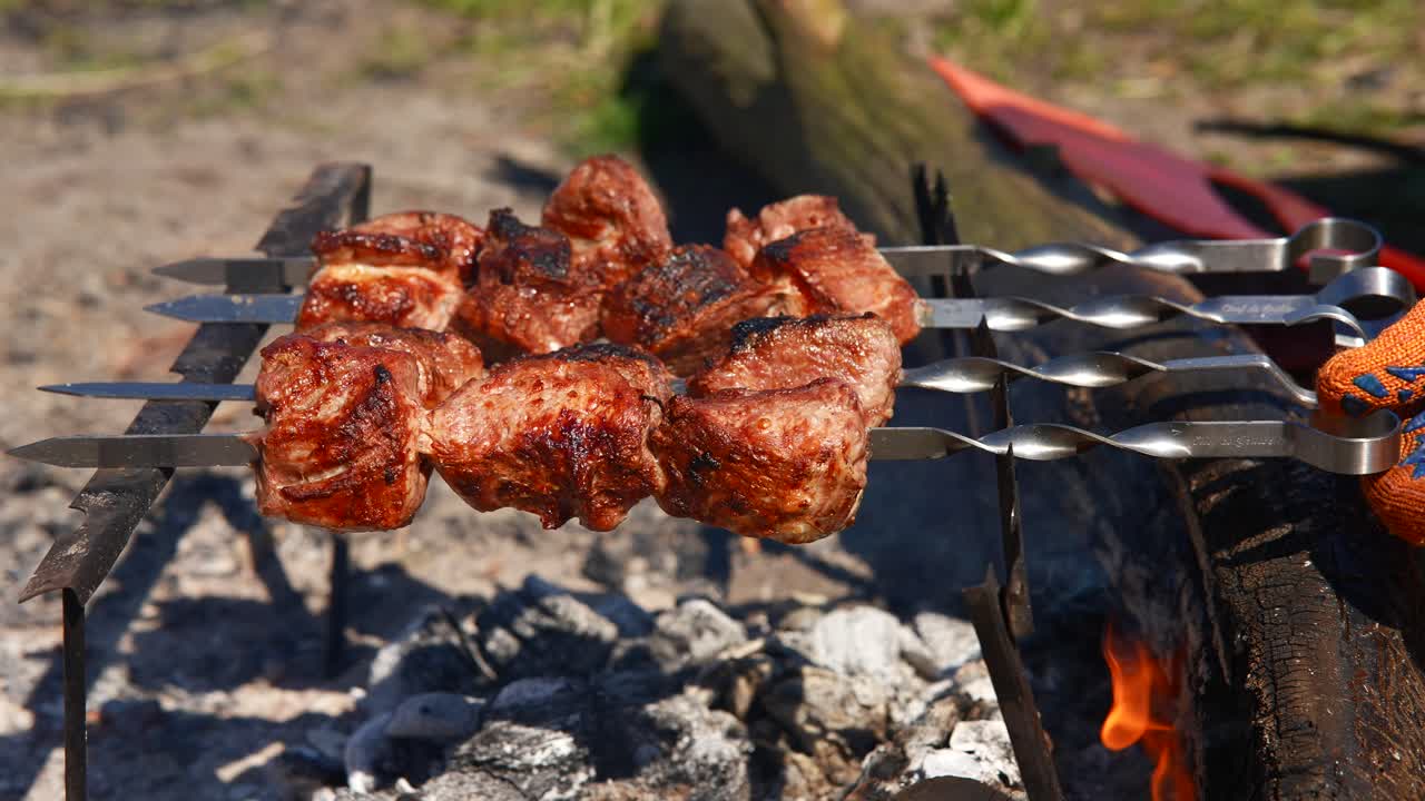 pinzas de carne a la parrilla en un fuego de campamento