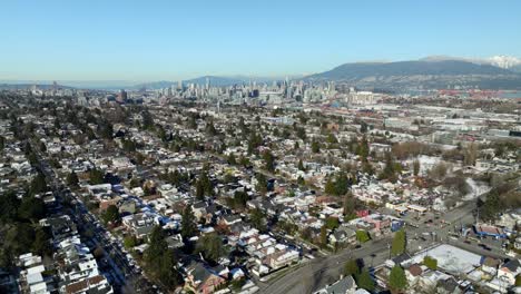 distant view of downtown vancouver skyline from knight street at 14th avenue in vancouver, bc, canada. aerial pullback shot