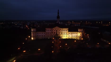 majestic beauty of the monastery castle in olomouc under the winter moon: a snow-covered wonderland with candlelit windows, frozen, snow-capped roofs, and a grand facade amidst a quiet winter night