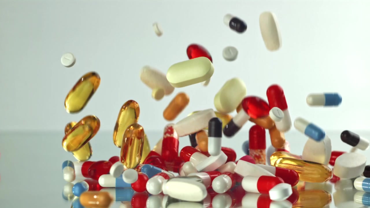 Colorful Pills and Capsules Falling in Slow Motion