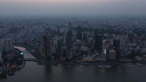 Ho-Chi-Minh-City,-Vietnam-iconic-Skyline-and-Saigon-river-waterfront-aerial-panorama-early-evening-featuring-all-key-buildings-reflected-in-the-river