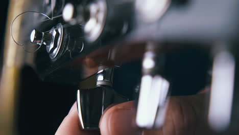 person tunes metal string on acoustic guitar at rehearsal