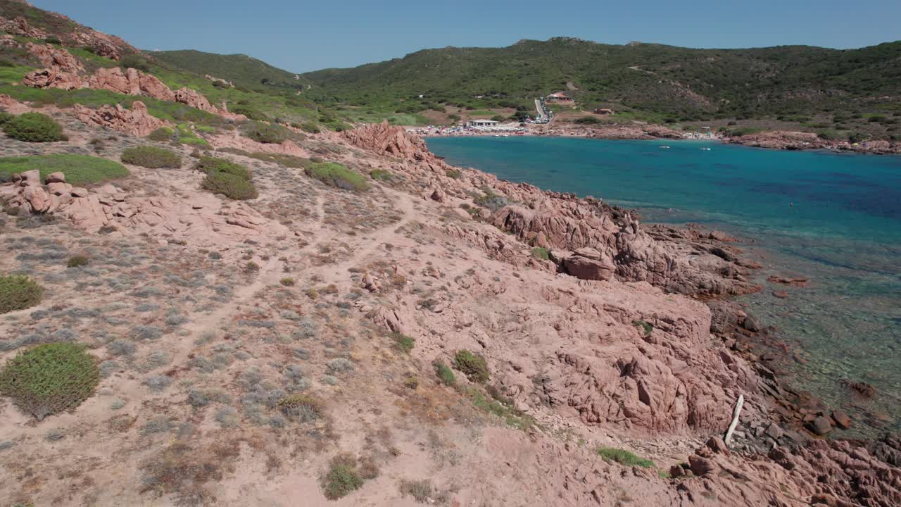 imágenes de viajes aéreos en la costa volcánica y rocosa con personas disfrutando del verano en sombrillas de playa