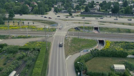 imágenes de aviones no tripulados de automóviles esperando detrás de un cruce ferroviario para que un tren pase y cruce en tallin, estonia, los países bálticos durante el verano