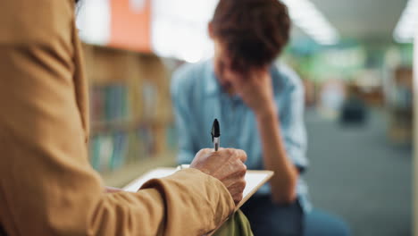 therapy session with therapist taking notes while patient expresses feelings