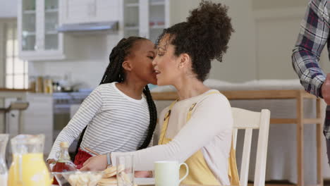 happy african american parents and daughter having breakfast at table, slow motion