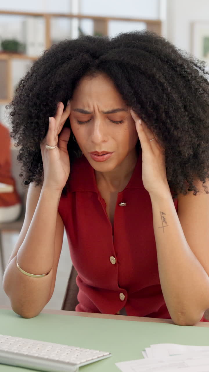 Donna che soffre di mal di testa e stress in ufficio